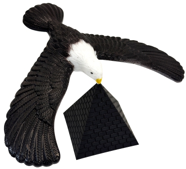 Seeadler liegt nur mit Schnabel auf Pyramide auf. Der Körper schwebt frei in der Luft.